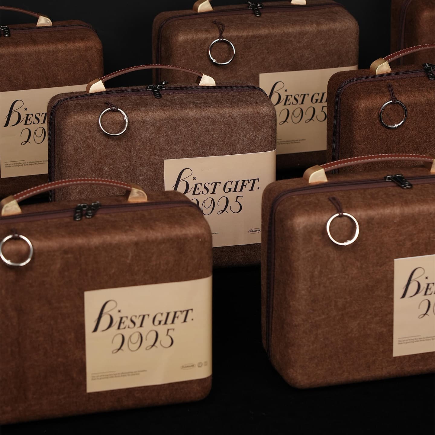 Several brown felt gift cases with leather handles and "BEST GIFT 2025" labels.