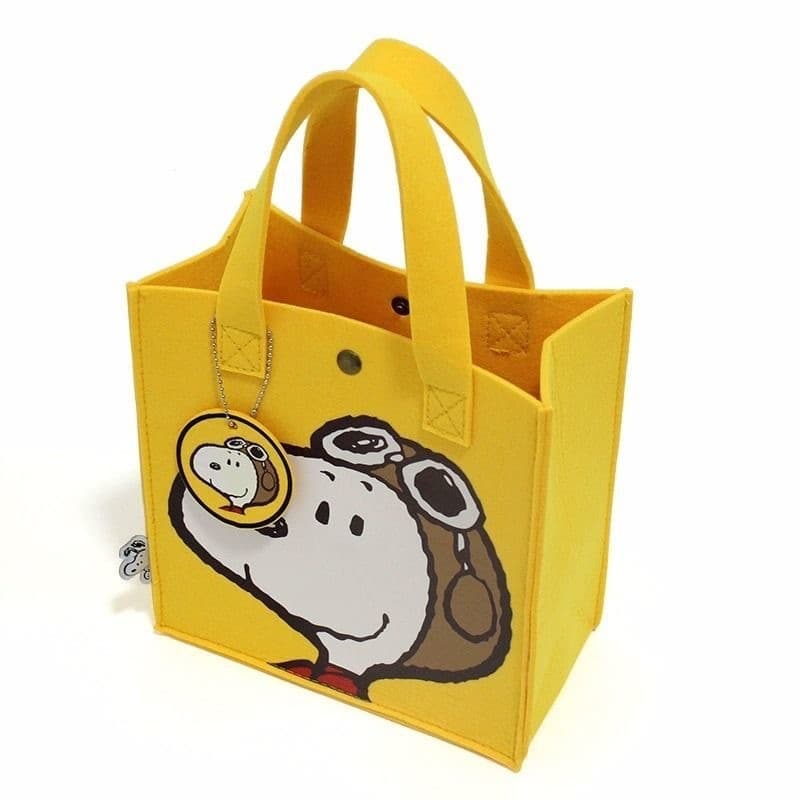 Bright yellow felt tote bag featuring Snoopy wearing aviator goggles and a matching circular keychain.